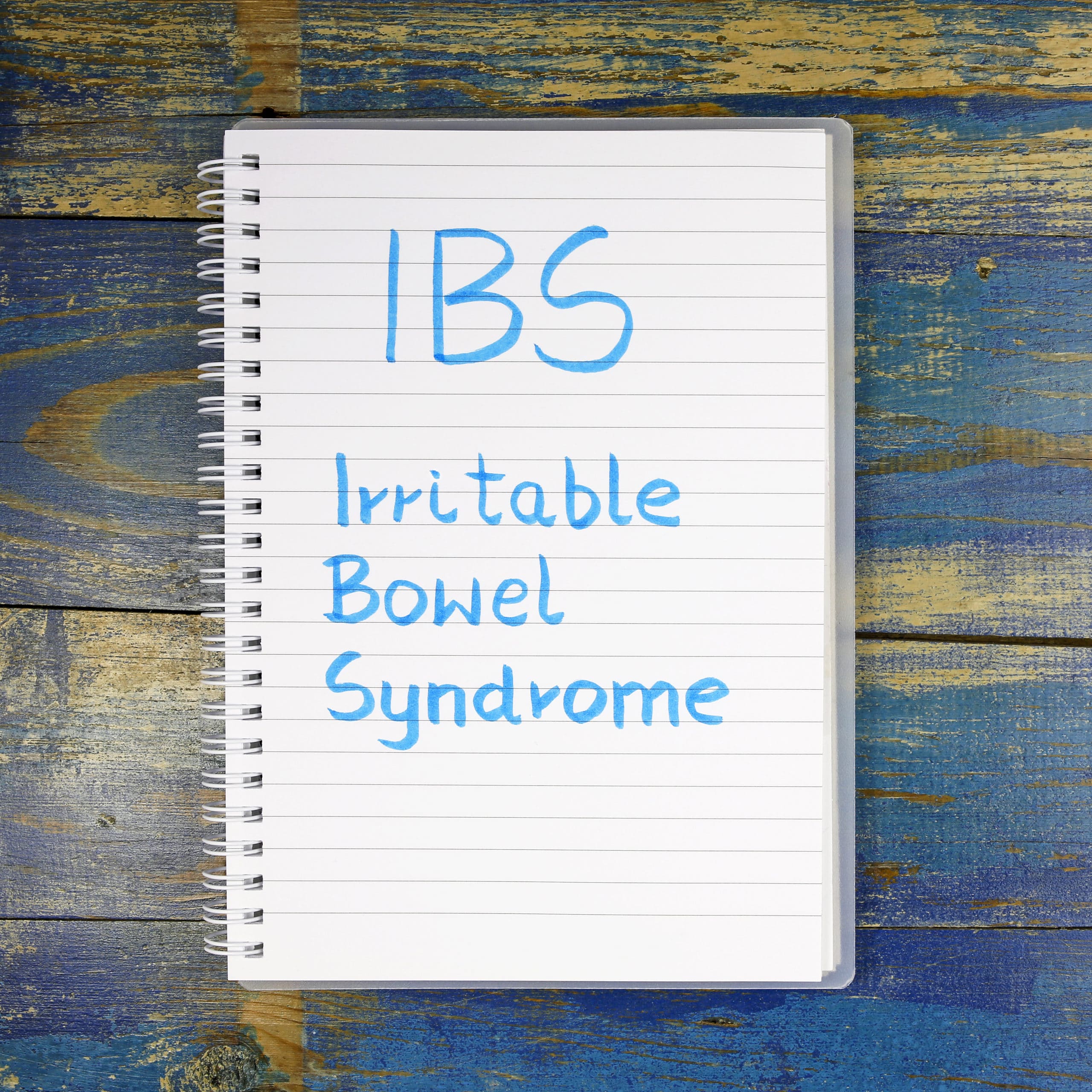 IBS- Irritable Bowel Syndrome written in notebook on wooden background